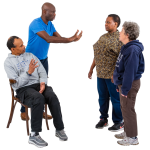 Four people having an animated conversation, with one person seated and three standing.